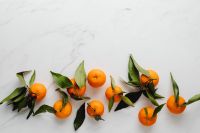 Kaboompics - Scattered Mandarins on White Marble with Open Space for Healthy Snack and Recipe Graphics
