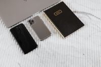 Kaboompics - Two Mobile Phones and Black 2020 Planner Beside Laptop on White Textured Table