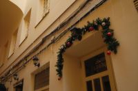 Kaboompics - Christmas Garland and Red Ornaments on a European Shop Entrance