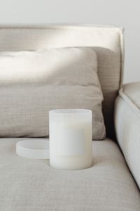 Kaboompics - White Candle Jar, Blank Label and Lid on Beige Sofa