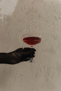 Kaboompics - Black Gloved Hand Holding a Red Cocktail Glass