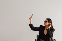 Kaboompics - Woman in a Black Suit Holding a Smartphone in a Chair