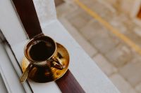 Kaboompics - Drink coffee in a golden cup at the window
