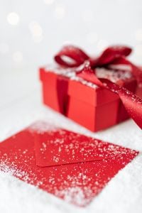 Kaboompics - Red Christmas Present and Matching Red Envelope on Snowy White Fabric