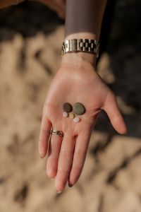 Kaboompics - Hand Holding Small Stones on the Beach