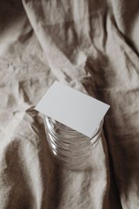 Kaboompics - Horizontal Business Card on Ribbed Glass Vessel, Linen Styling