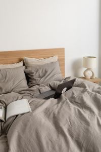 Kaboompics - Laptop and Open Book on a Minimalist Bed