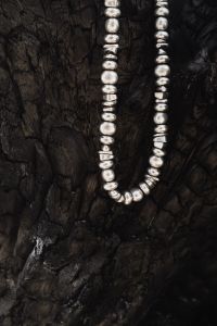 Kaboompics - Silver Beaded Necklace on Black Driftwood