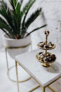 Kaboompics - Soft-Focus Palm Leaves Framing a Gold Quail Egg Stand