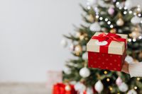 Kaboompics - Small Christmas Gift with Tree Bokeh and Copy Space