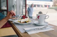 Kaboompics - Woman Enjoying Cheese Cake and a Coffee with Fruits in a Cafeteria