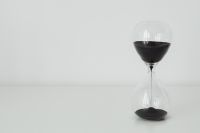 Kaboompics - Black Sand Hourglass on a White Surface with Generous Left Copy Space