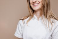Kaboompics - Smiling Female Dentist in White Coat with Healthy Teeth, Dental Care Portrait for Oral Health Campaigns