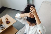 Kaboompics - Woman Tying Her Hair in Soft Interior Light