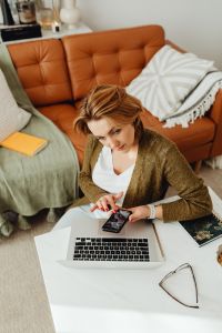 Kaboompics - Remote Work from Home: Woman on Phone with Laptop in Her Lap