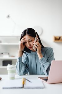 Kaboompics - Stressed Asian Woman Juggling a Phone Call and Laptop Work