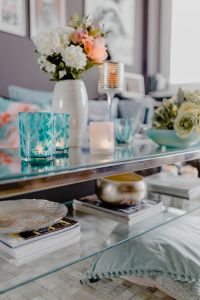 Kaboompics - White and Peach Flowers with Turquoise Glassware and a Candle on Glass Table