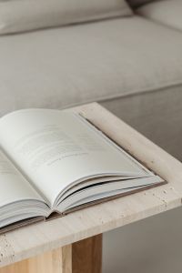 Kaboompics - Open Interior Design Book on Travertine Coffee Table Beside Sofa