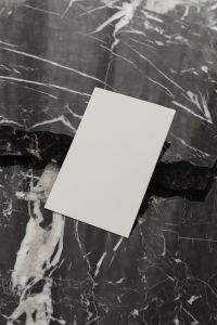 Kaboompics - Tilted Vertical White Business Card Mockup on Dark Veined Marble
