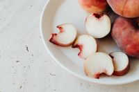 Kaboompics - Peach Slices and Whole Fruit in White Plate, Minimal Kitchen Still Life