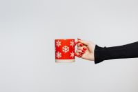 Kaboompics - Red Snowflake Mug in Hand on a Wide White Background, Festive Christmas Drink Copy Space