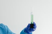 Kaboompics - Green Liquid in a Graduated Cylinder on White Background