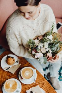 Kaboompics - Latte Cups, Pastries and a Pastel Bouquet on a Cafe Table