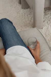 Kaboompics - Woman Holding a Glass on a Neutral Sofa