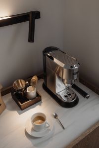 Kaboompics - Coffee Cup and Espresso Machine Under Black Wall Lamp