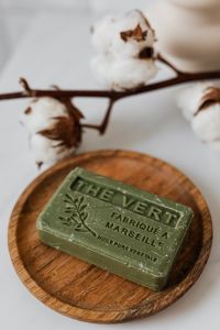 Kaboompics - Macro Olive Soap on a Wooden Tray with Cotton Branch, Natural Soap Product Photography