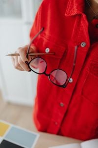 Kaboompics - Close-Up of Eyeglasses and Pencil Held over Red Blouse beside Color Palette