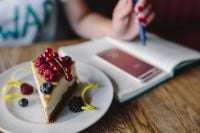 Kaboompics - Berry Cheesecake Slice with Notebook and Red Pen