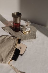 Kaboompics - Chanel No. 5 Perfume and Dom Rosa Bottle on Stone Slab with Makeup