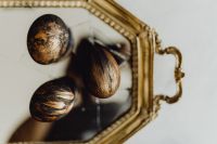Kaboompics - Three Mottled Metallic Easter Eggs on an Antique Gold Mirror Tray