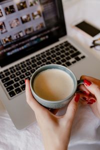 Woman Working from Bed with Laptop and Coffee, Cozy Remote Work Lifestyle and Home Office Setup