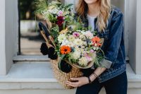 Kaboompics - Seated Woman with Large Wicker Basket of Mixed Flowers