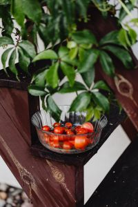 Kaboompics - Glass Bowl of Homegrown Tomatoes Beneath a Potted Garden Plant