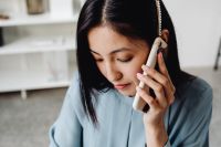 Kaboompics - Asian Woman Listening on a Smartphone at Her Desk