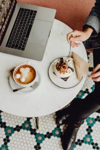 Kaboompics - Working with a laptop, meringue with whipped cream and coffee on white marble