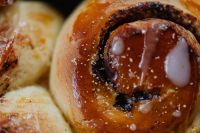 Kaboompics - Golden Cinnamon Roll with White Icing Close-Up for Bakery Menu Photography