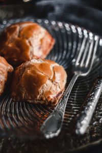 Kaboompics - Three Sweet Buns on a Black Ribbed Plate with Silver Cutlery