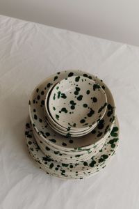 Kaboompics - Green Splatter Dinnerware Stack on Wrinkled Linen