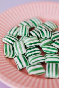 Kaboompics - Green and White Striped Candies in a Pink Plate, Close-Up Food Photo
