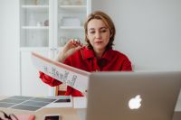 Kaboompics - Woman Reviewing Color Swatches beside Laptop at Home Office Desk