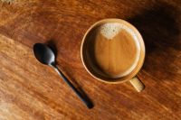 Kaboompics - Foamy Coffee Cup and Black Spoon on Rustic Wood, Overhead View