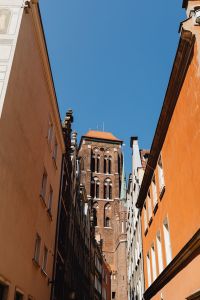 Kaboompics - Historic Brick Tower Framed by Colorful Gdańsk Old Town Facades