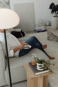 Kaboompics - Woman Eating Dessert on a Sofa Beside a Potted Plant