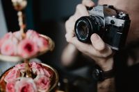 Kaboompics - Close-Up Camera Lens Beside a Pink Rose Display