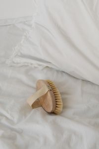 Kaboompics - Wooden Body Brush on White Linen with Relaxing Self-Care Copy Space