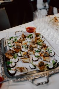 Kaboompics - Savory Canape Platter with Fresh Herbs, Dipping Sauce and Rows of Glasses
